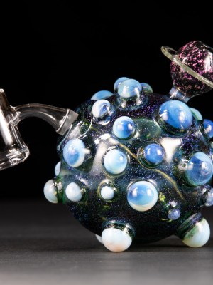 Dab rig made of glass. Black glass mouthpiece, white and blue glass balls on the majority of the rig